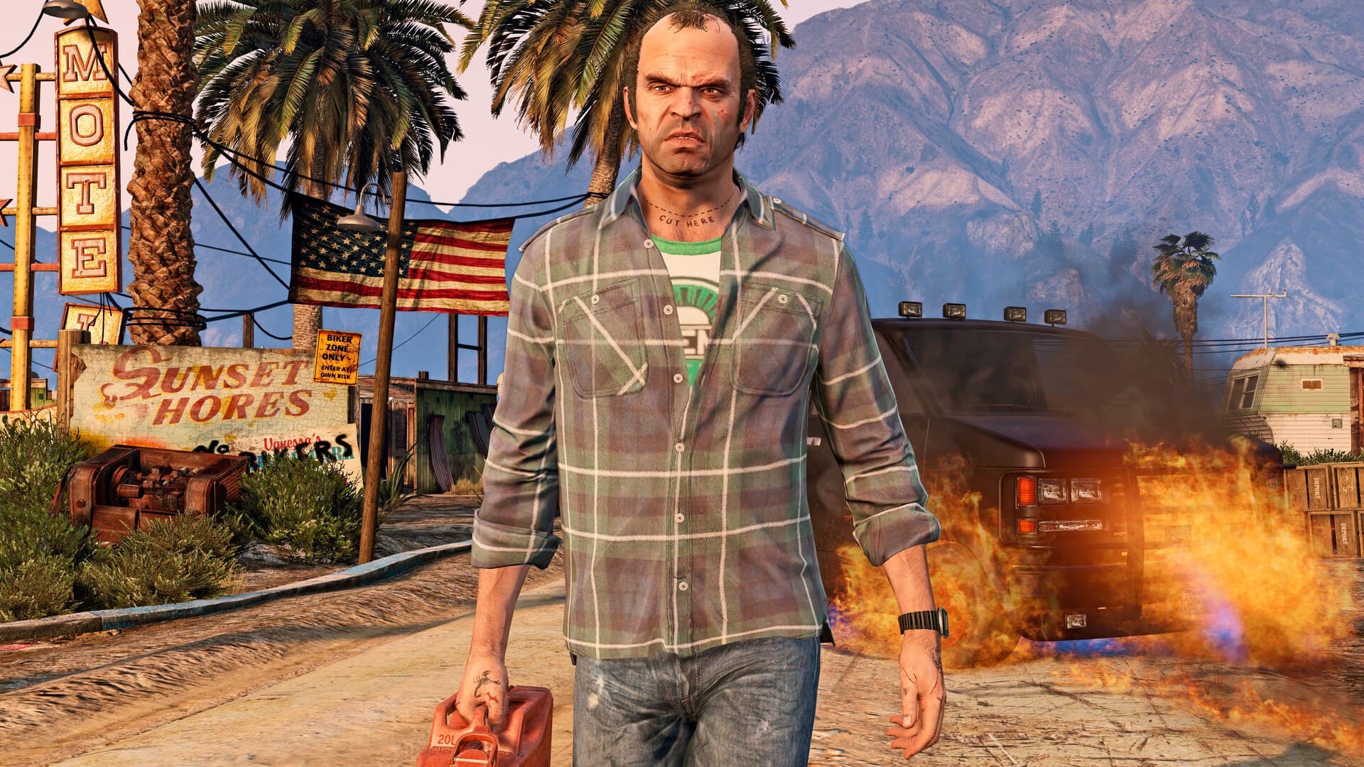 Imagem oficial de GTA V com Trevor caminhando diante de um motel em chamas