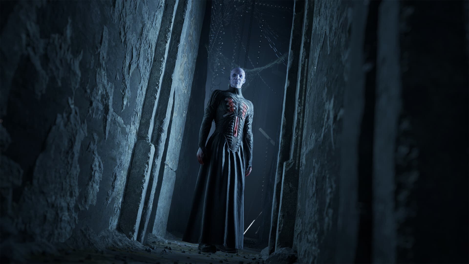 O Pinhead de pé num corredor de pedra escura em Clive Barker's Hellraiser: Revival
