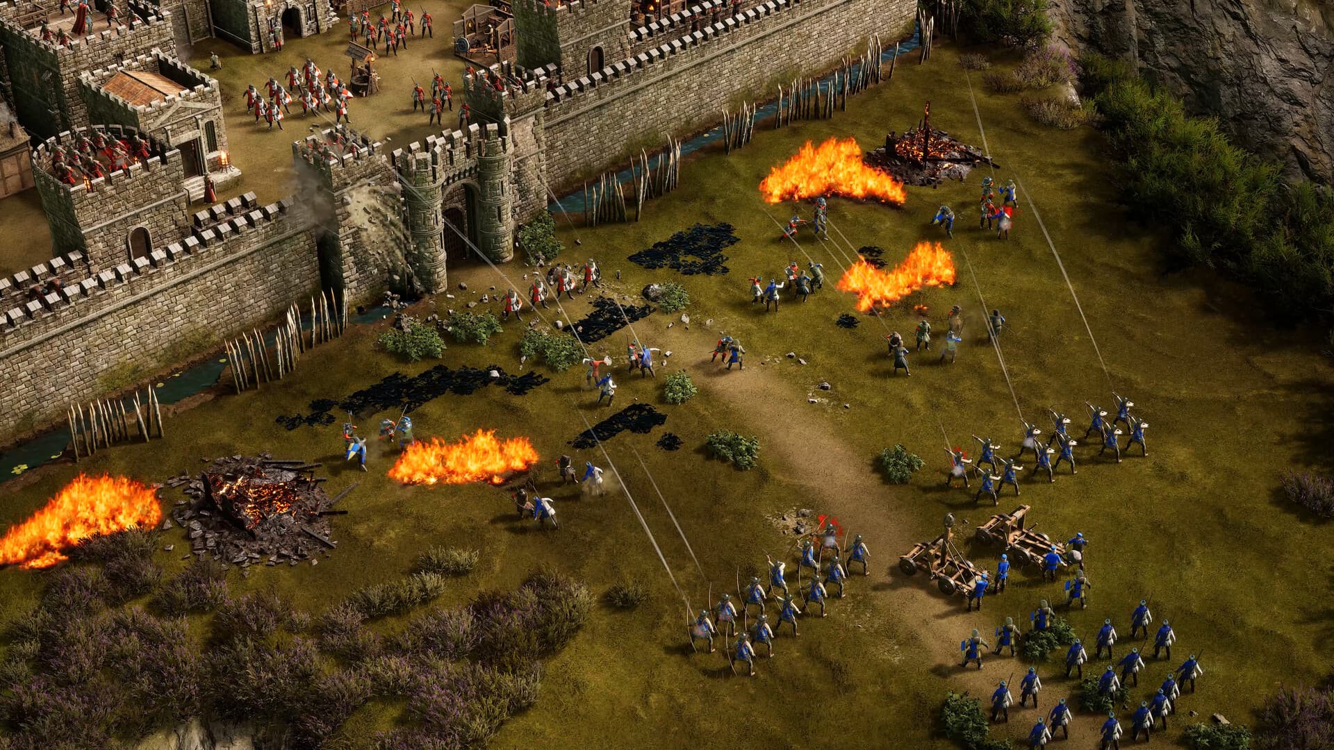 Um cerco com fogo e exércitos diante da muralha em Stronghold 4.