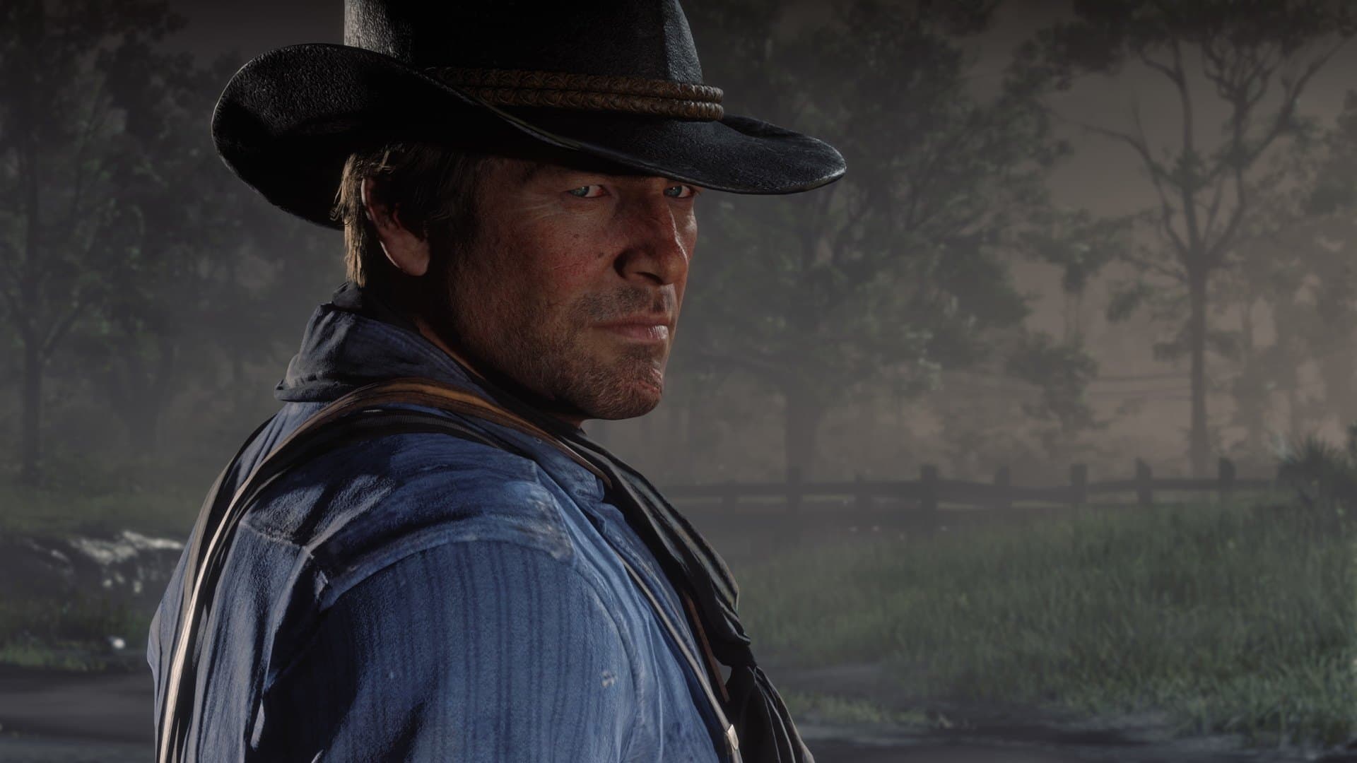 Arthur Morgan de chapéu em close numa estrada de terra em imagem oficial de Red Dead Redemption 2