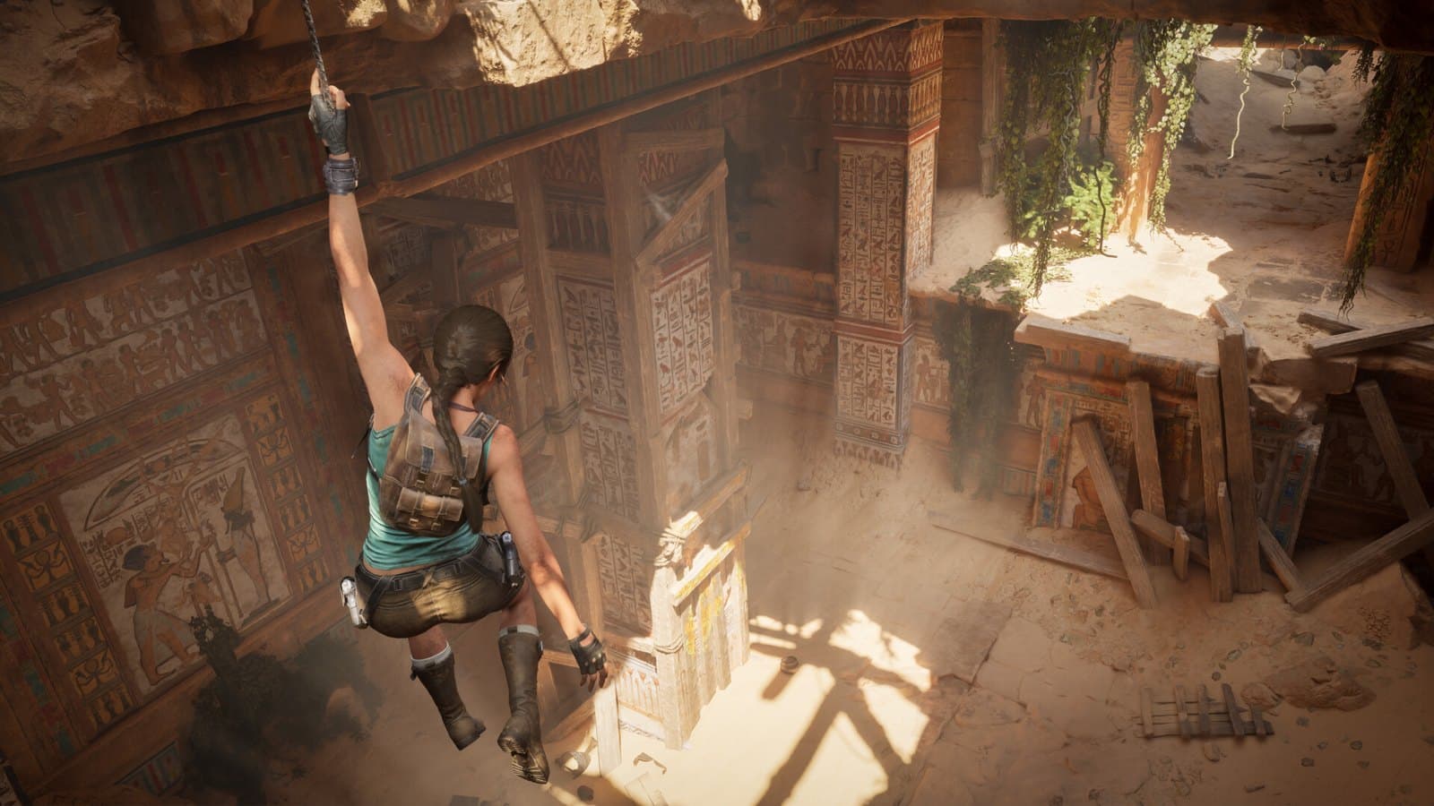 Lara Croft escala uma parede dentro de uma tumba iluminada por luz natural em Tomb Raider: Legacy of Atlantis