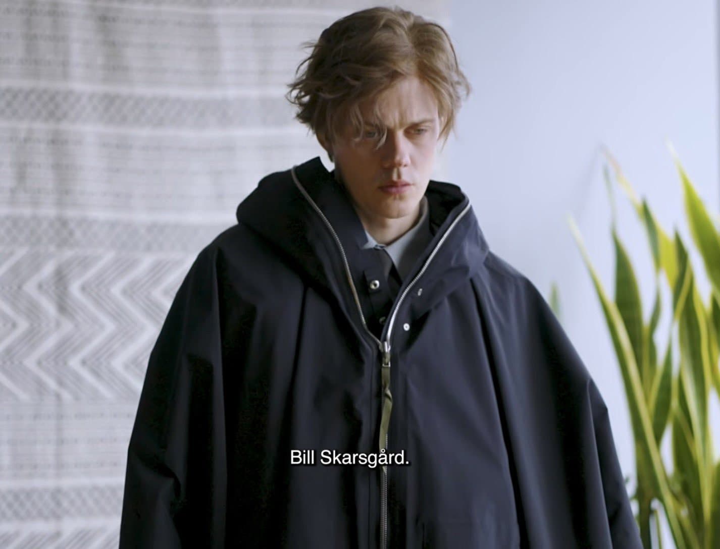 Skarsgård com a capa da ACRONYM no vídeo de bastidores exibido ao lado dos figurinos.